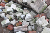 Stavební odpad s prvky a zničenými starými stavbami na městské skládce