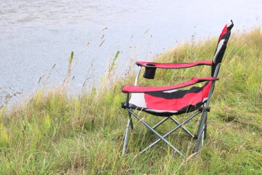 Nehir yakınındaki parkta sonbaharda Turist sandalye
