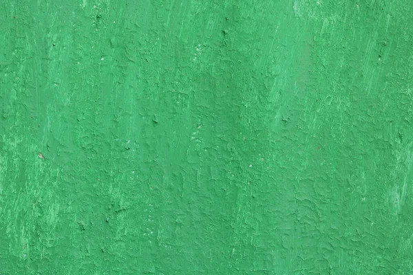 Beautiful vintage green background with old green paint with a rough surface, streaks and uneven texture of green paint on an old rough surface