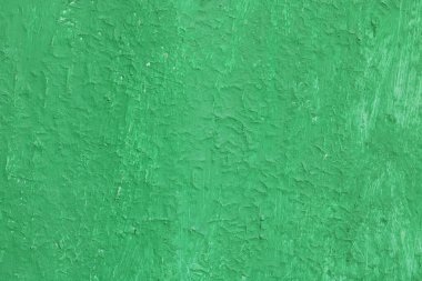 Eski, pürüzlü bir yüzeyi olan eski yeşil boyalı, eski ve pürüzlü bir yüzeyde yeşil rengin çizgileri ve pürüzlü dokusuna sahip güzel, eski yeşil bir arka plan.