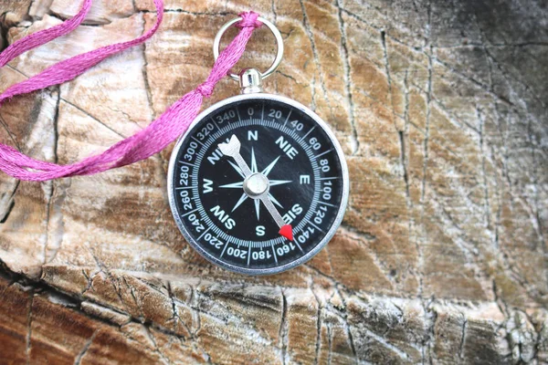 Old compass on natural wooden background