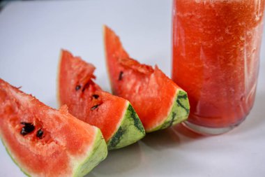 Beyaz arka planda dilimlenmiş karpuz suyu