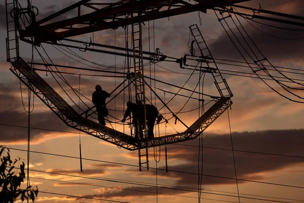 Trabajadores en una torre de alto voltaje — Foto de Stock