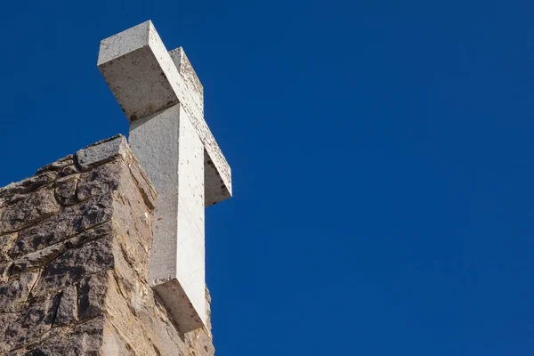 Cruz de pedra contra o céu azul — Fotografia de Stock