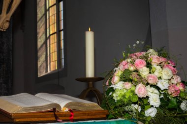 İncil, mum ve çiçekler ile altar