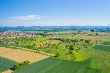 Kırsal bir köy olan Wolfschlugen ve Almanya 'nın arka planında Suabian Albleri olan tarlalar ve çayırlar.