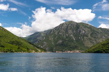 Landscape of mountains, sea and the small towns in the Boka Kotor bay of the Mediterranean Sea sunny day and white clouds. Montenegro.