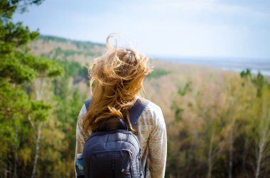 Genç güzel kız ormanda, mesafe bakarak arkadan görünümü