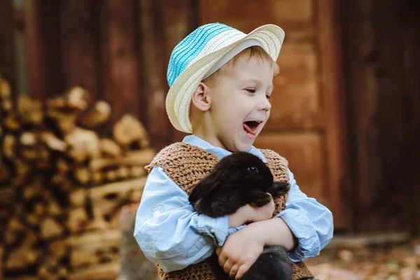 O menino na fazenda com um coelho — Fotografia de Stock