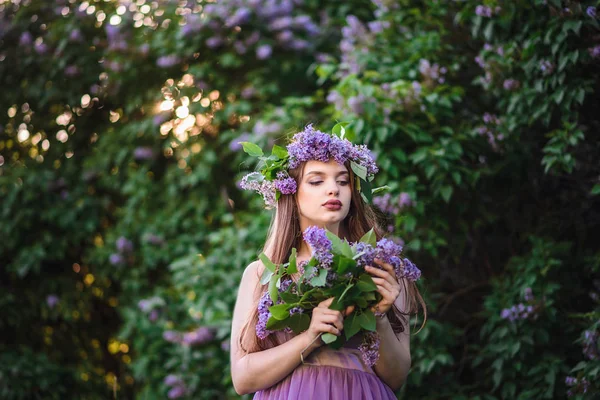 Das Mädchen mit dem Kranz auf dem Haupt in Flieder — Stockfoto