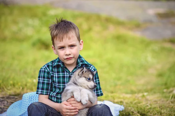 Le garçon avec le chiot touffu — Photo