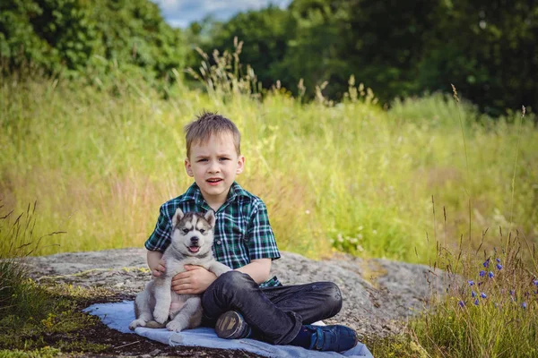 O menino com filhote de cachorro husky — Fotografia de Stock