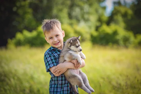 Le garçon avec le chiot touffu — Photo