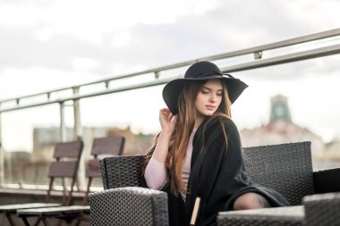 Kız şapka çapında ekledi ve Cape Restoran balkonda oturup