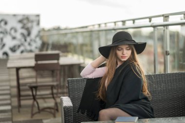 Kız şapka çapında ekledi ve Cape Restoran balkonda oturup