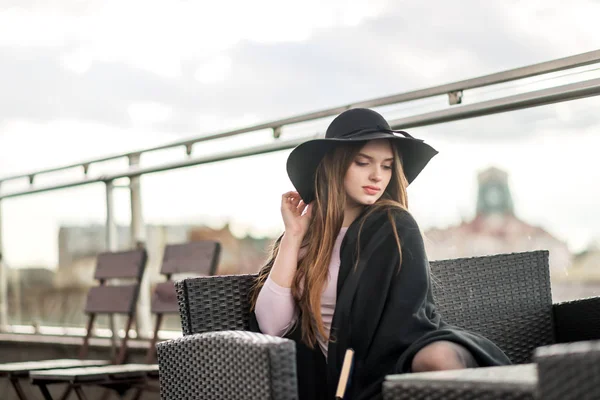 Kız şapka çapında ekledi ve Cape Restoran balkonda oturup