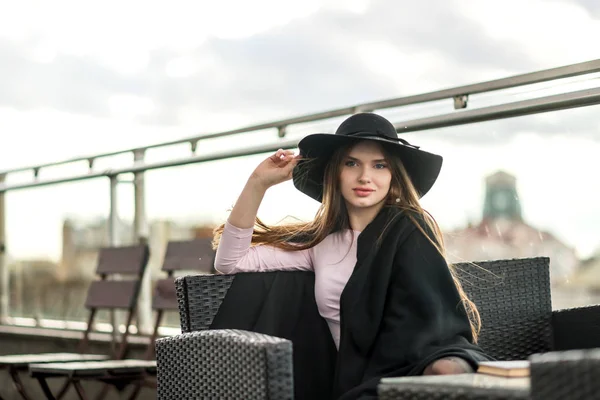 Kız şapka çapında ekledi ve Cape Restoran balkonda oturup