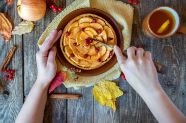 kadının elleri elmalı turta Ahşap dokusu üzerinde kesmek.