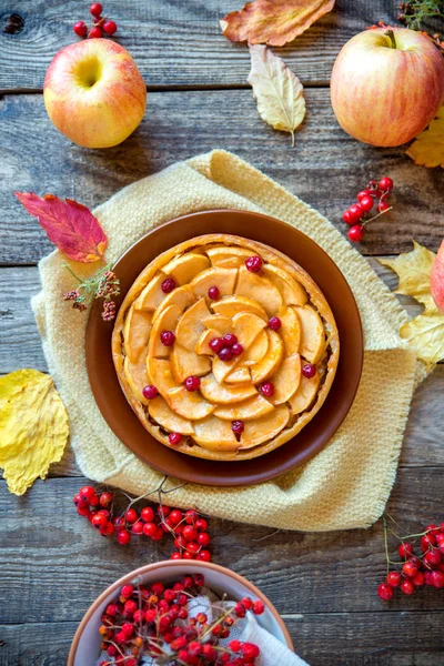 Apple pie on a wooden texture with red berries — Stock Photo, Image