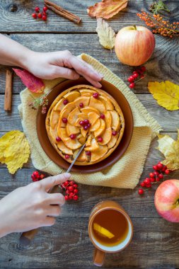 kadının elleri elmalı turta Ahşap dokusu üzerinde kesmek.