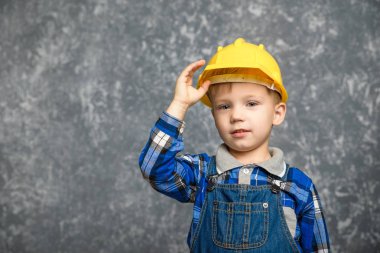 Bir çocuk bir inşaat tutar kask ve gülümseyen