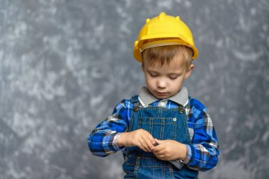 Bir çocuk inşaat kask tutar 