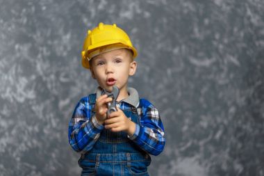 Sarı sert şapkalı beyinameliyatı elinde tutan çocuk