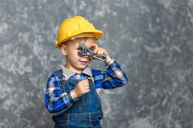 Sarı sert şapkalı beyinameliyatı elinde tutan çocuk
