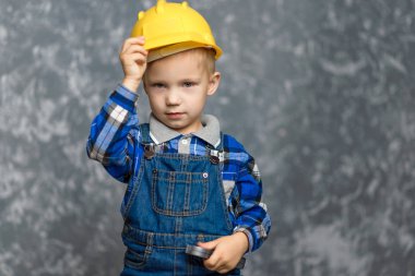 Bir çocuk bir inşaat tutar kask ve gülümseyen