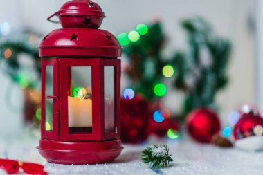 mum çam dalları ve bulanık ışıklar çelenk beyaz zemin üzerine kırmızı Noel fener