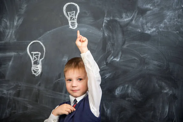 Der Junge hat eine Idee, die auf dem Brett Glühbirne gezeichnet — Stockfoto