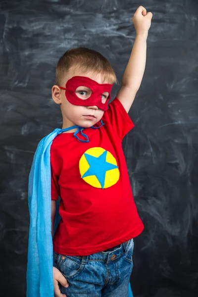 Мальчик супергерой в синей красной маске и красной футболке со звездой — стоковое фото