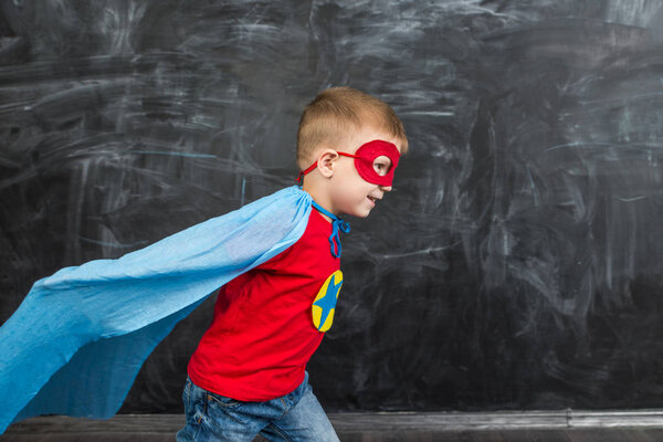 boy superhero in a blue Cape red mask and a red t-shirt with a star