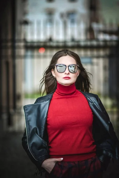 Havalı kız siyah deri ceket ve güneş gözlüğü, şehrin içinden yürür — Stok fotoğraf