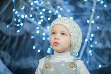 Mavi ışıklar bir arka plan üzerinde beyaz şapkalı çocuk