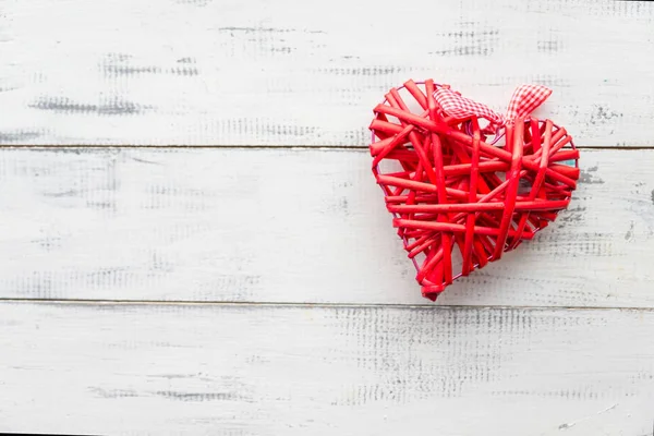 Rode rieten hart op een witte houten achtergrond — Stockfoto