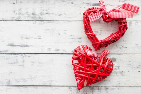 Червоне плетене серце на білому дерев'яному фоні — стокове фото