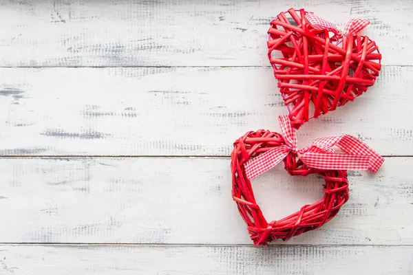 Червоне плетене серце на білому дерев'яному фоні — стокове фото