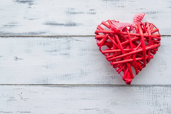 Rode rieten hart op een witte houten achtergrond — Stockfoto