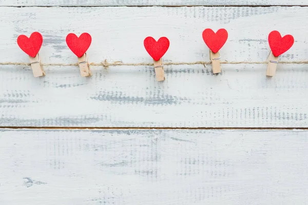 Veelkleurige harten met inscripties aan een touw op een houten achtergrond — Stockfoto