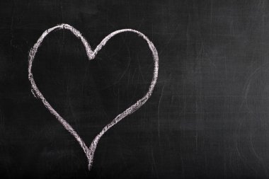 Beyaz tebeşir siyah bir zemin üzerine çizilmiş kalp