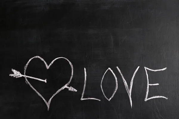 white chalk painted heart with love lettering on a black slate