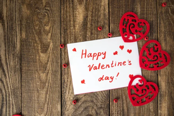 Белая нота с надписью "С Днем Святого Валентина" в рамке на сердце на деревянном фоне — стоковое фото
