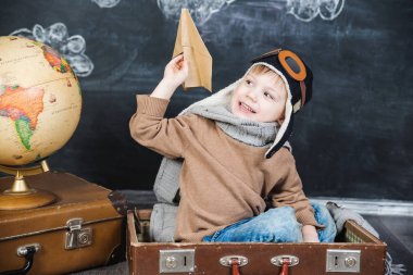 bir kağıt uçak pilot şapkalı çocuk çalış