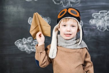 bir kağıt uçak pilot şapkalı çocuk çalış