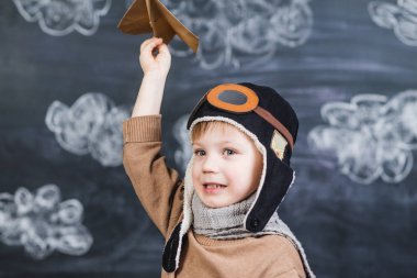 bir kağıt uçak pilot şapkalı çocuk çalış