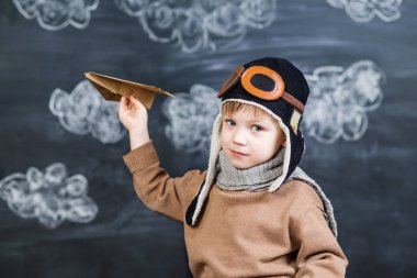bir kağıt uçak pilot şapkalı çocuk çalış
