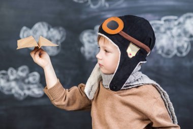 bir kağıt uçak pilot şapkalı çocuk çalış