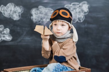 bir kağıt uçak pilot şapkalı çocuk çalış
