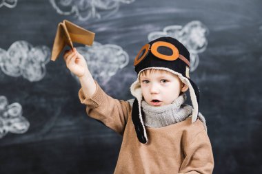 bir kağıt uçak pilot şapkalı çocuk çalış